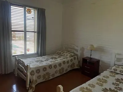 a bedroom with two beds and a window at Casa Lac - Vista al Lago - No se aceptan grupos de jóvenes in Villa Carlos Paz