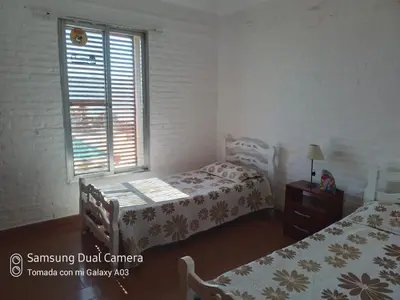 a bedroom with two beds and a window at Casa Lac - Vista al Lago - No se aceptan grupos de jóvenes in Villa Carlos Paz