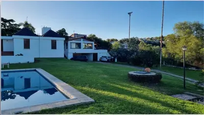 a yard with a swimming pool and a house at Casa Lac - Vista al Lago - No se aceptan grupos de jóvenes in Villa Carlos Paz