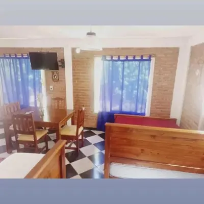 a living room with a table and chairs and a dining room at Complejo José León in Arroyo de Los Patos