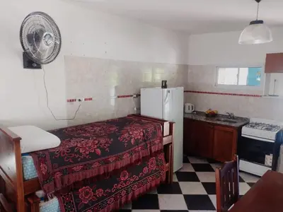 a small kitchen with a bed and a refrigerator at Complejo José León in Arroyo de Los Patos