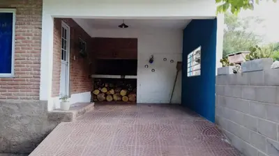 a building with a garage with a bunch of logs at Complejo José León in Arroyo de Los Patos