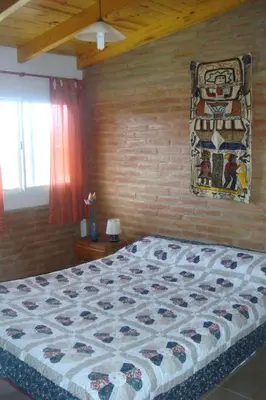 a bedroom with a bed with a quilt on it at Cerritos Departamento in Villa Carlos Paz