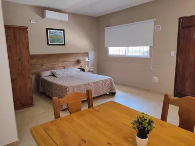 a bedroom with a bed and a table in a room at Residencial Buenos Aires in Mina Clavero