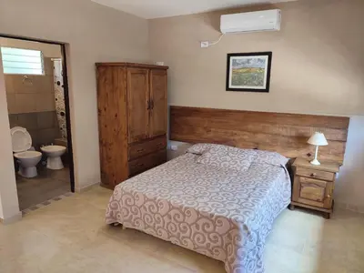 a bedroom with a bed and a bathroom with a toilet at Residencial Buenos Aires in Mina Clavero