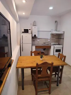 a kitchen with a wooden table and chairs at Residencial Buenos Aires in Mina Clavero