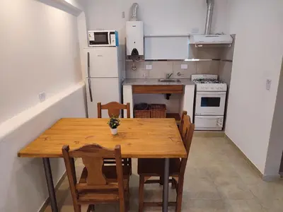 a small kitchen with a wooden table and chairs at Residencial Buenos Aires in Mina Clavero