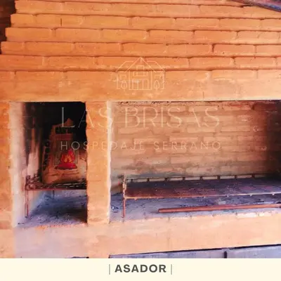 a brick wall with a bench in front of a building at Las Brisas - Hospedaje Serrano in Santa María