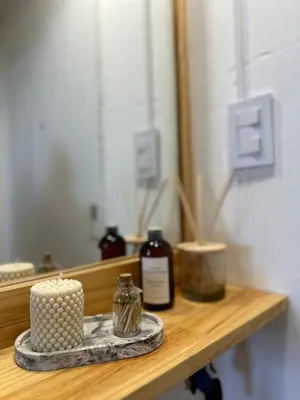 a candle sitting on a wooden shelf with a mirror at Duplex peatonal in Villa Carlos Paz