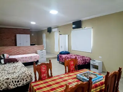 a room with two beds and a projection screen at Atardecer Serrano in Nono