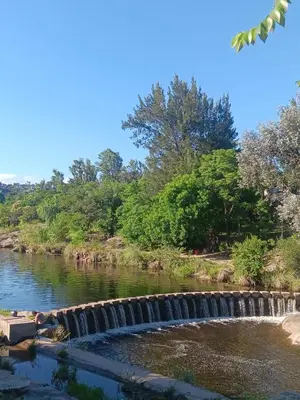 a river with a waterfall in the middle at Cabaña frente al balneario diquecito solo familias in Villa Carlos Paz