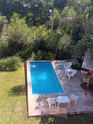 a small swimming pool with chairs and a bench at Cabaña frente al balneario diquecito solo familias in Villa Carlos Paz