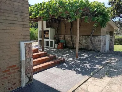 a house with stairs and a stone wall at Casa Ranqueles in Villa Carlos Paz