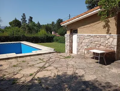 a backyard with a swimming pool next to a building at Casa Ranqueles in Villa Carlos Paz