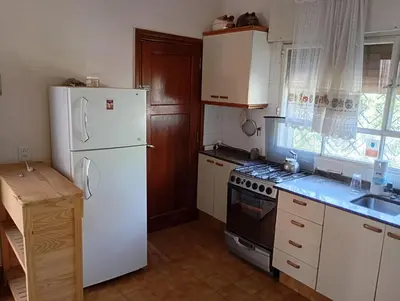 a kitchen with white appliances and a white refrigerator at Casa Ranqueles in Villa Carlos Paz