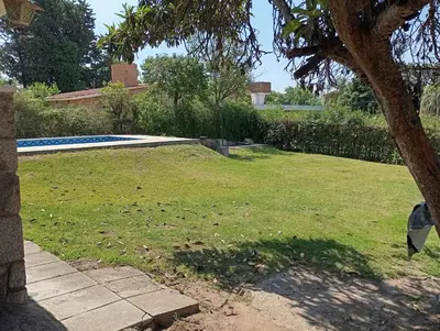 a yard with a swimming pool and a tree at Casa Ranqueles in Villa Carlos Paz