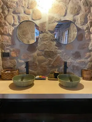 two bowls sitting on a counter with two mirrors at Puesto de Montaña - Casa con pileta privada in Los Hornillos