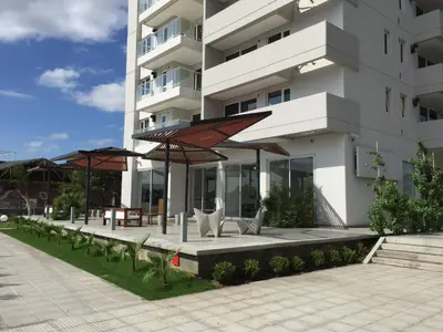 a building with benches and umbrellas in front of it at Rent a Flat in Cordoba