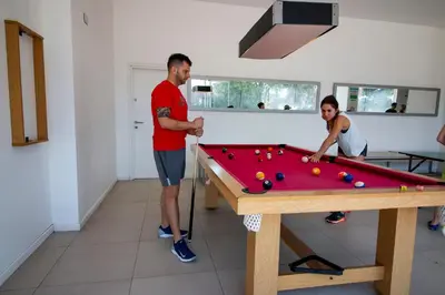 two men playing a game of snooker at Rent a Flat in Cordoba