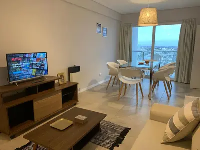 a living room with a television and a table with chairs at Rent a Flat in Cordoba