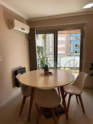 a table and chairs in a room with a balcony at Beautiful apartment in Cordoba