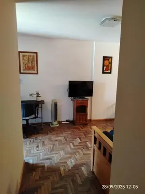 a living room with a wooden floor and a flat screen tv at Corazón de Nueva Córdoba in Cordoba
