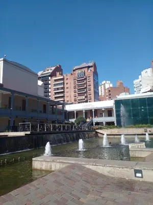 a fountain in the middle of a city with buildings at Corazón de Nueva Córdoba in Cordoba