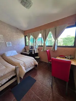 a bedroom with two beds and a desk with a computer at Hospedaje Del Rosario in Santa María