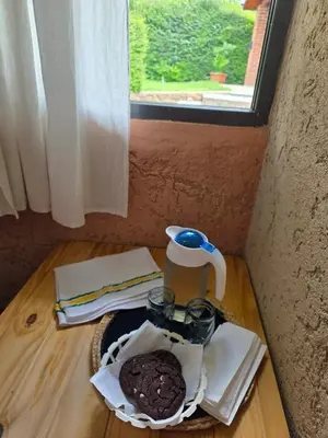 a table with a coffee pot and a cookie on it at Hospedaje Del Rosario in Santa María