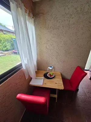 a table with two red chairs and a plate of food at Hospedaje Del Rosario in Santa María