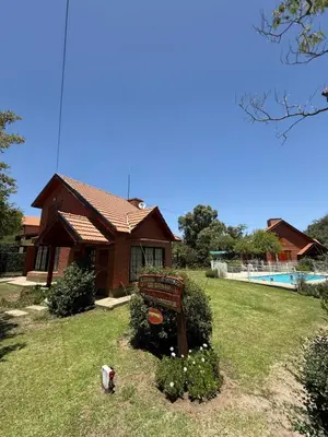 a house with a bench in front of a yard at Cabaña Los Estribos 1 in Merlo