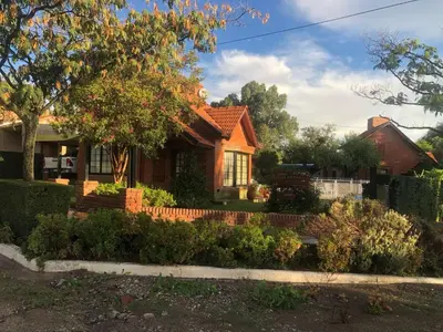 a house with a garden in front of it at Cabaña Los Estribos 1 in Merlo