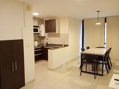 a kitchen and dining room with a table and chairs at Dúplex con balcón en Nueva Córdoba by Lofty in Cordoba