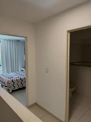 a bedroom with a bed and a door to a bathroom at Dúplex con balcón en Nueva Córdoba by Lofty in Cordoba