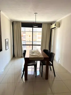 a dining table and chairs in a room with a window at Dúplex con balcón en Nueva Córdoba by Lofty in Cordoba