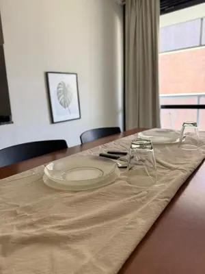 a wooden table with plates and glasses on it at Dúplex con balcón en Nueva Córdoba by Lofty in Cordoba