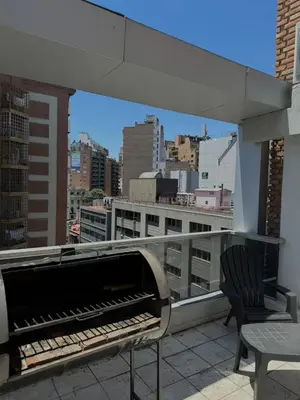 a piano on a balcony with a view of a city at Dúplex con balcón en Nueva Córdoba by Lofty in Cordoba