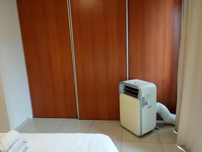 a small refrigerator sitting in front of a wooden door at Dúplex con balcón en Nueva Córdoba by Lofty in Cordoba