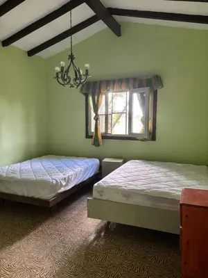 two beds in a room with a window at Refugio de Nestor in Villa Parque Siquiman