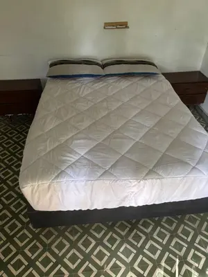 a bed in a room with a white bedsheet at Refugio de Nestor in Villa Parque Siquiman