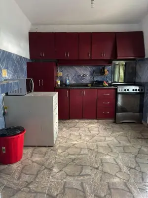 a kitchen with red cabinets and a stove top oven at Refugio de Nestor in Villa Parque Siquiman