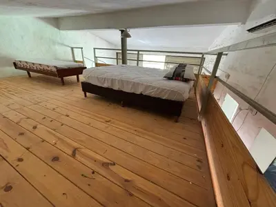 a large room with a bed and a bench on a boat at Refugio de Nestor in Villa Parque Siquiman