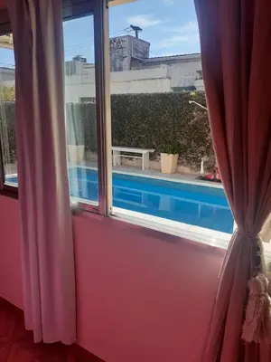 a window with a view of a swimming pool at lo de carla in Villa Carlos Paz
