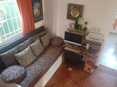 a living room with a couch and a desk with a computer at lo de carla in Villa Carlos Paz