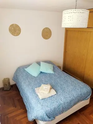 a bedroom with a bed with blue sheets and blue pillows at El Sol de Vilaró Dpto a mts de todo in Cordoba