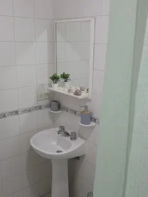 a white bathroom with a sink and a mirror at El Sol de Vilaró Dpto a mts de todo in Cordoba