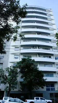 a tall white building with cars parked in front of it at El Sol de Vilaró Dpto a mts de todo in Cordoba