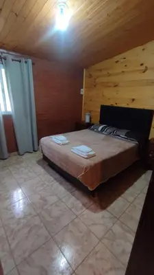 a bedroom with a large bed in a wooden room at Las tres lunas in Villa Anizacate