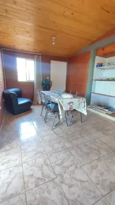 a living room with a table and a chair at Las tres lunas in Villa Anizacate