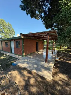 a building with a wooden pavilion in a park at Las tres lunas in Villa Anizacate